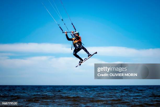 Former Finnish Olympic gymnastics athlete in Rome and Tokyo , Kauko Heikkinen jumps as he rides a kitesurf in Storsand, northern Vaasa, western...