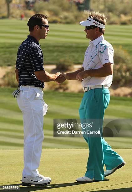 Paul Casey of England and Brian Gay shake hands after completing their round on the 14th hole during round three of the Accenture Match Play...