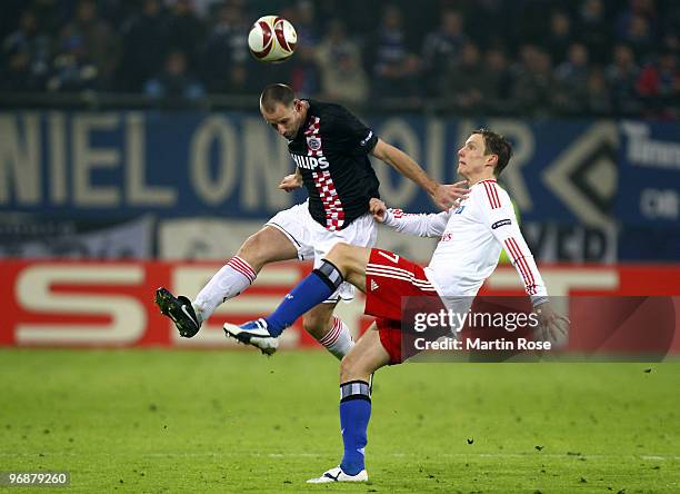 Marcell Jansen of Hamburg and Andre Ooijer of Eindhoven compete for the ball during the UEFA Europa League knock-out round, first leg match between...