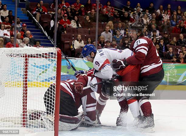Milan Michalek of Czech Republic scrambles for the puck with Armands Berzins, Georgijs Pujacs and goalkeeper Edgars Masalskis of Latvia during the...