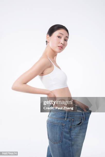young chinese dieting woman showing weight loss - cami - fotografias e filmes do acervo