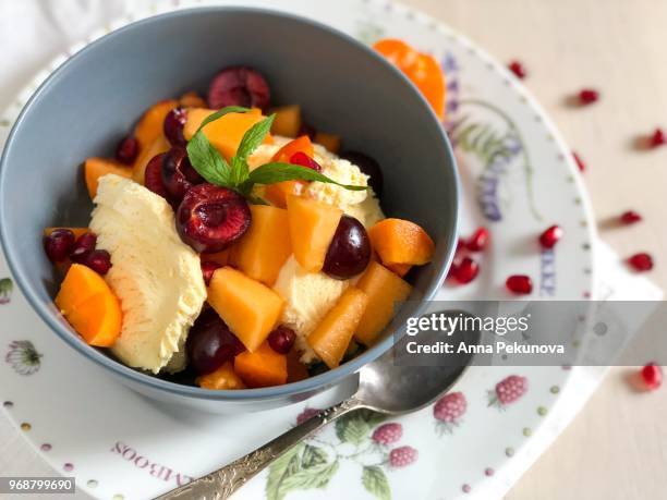 bowl of ice cream with fruits ready to eat - anna pekunova stock-fotos und bilder