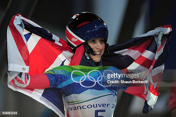 Amy Williams of Great Britain and Northern Ireland celebrates with her countries flag after she completed her run to win the gold medal in the...