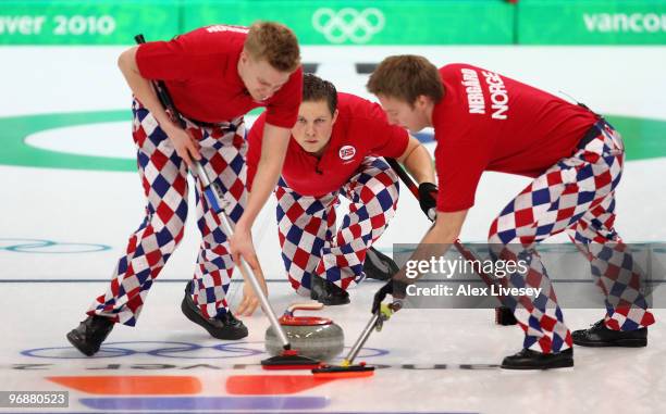 Christoffer Svae releases a stone as Haavard Vad Petersson and Torger Nergaard brush the ice during the Men's Curling Round Robin match between...