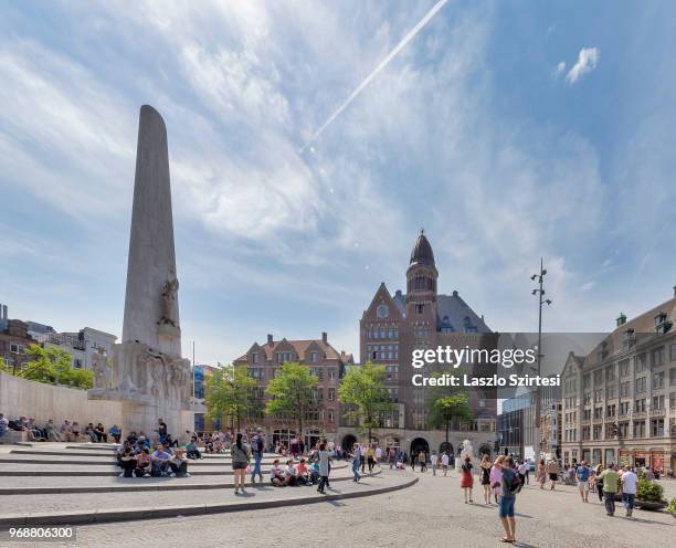 Tourists take some rest next to the National Monument at the Dam Square on May 27, 2018 in Amsterdam, Netherlands. This monument lets people...