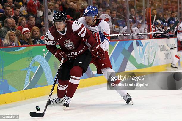Milan Michalek of Czech Republic challenges Georgijs Pujacs of Latvia for the puck during the ice hockey men's preliminary game between Czech...