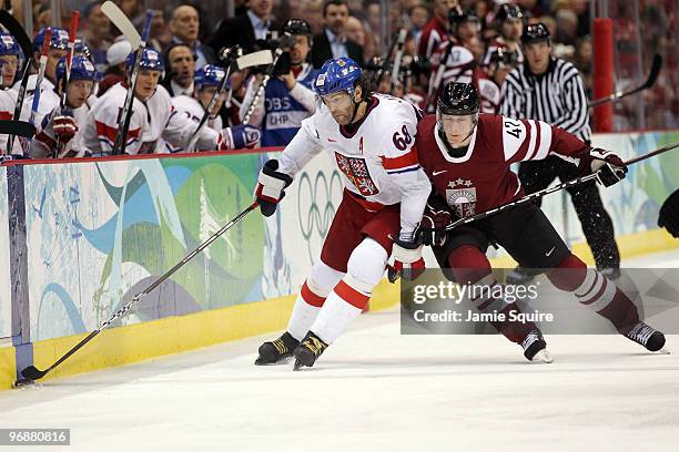 Martins Cipulis of Latvia checks Jaromir Jagr of Czech Republic against the boards during the ice hockey men's preliminary game between Czech...