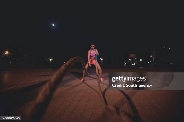 exercising with battle ropes - battle rope stock pictures, royalty-free photos & images