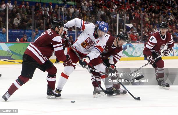 Kristaps Sotnieks and Kaspars Daugavins of Latvia challenge Jaromir Jagr of Czech Republic for the puck during the ice hockey men's preliminary game...