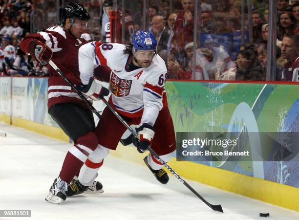 Jaromir Jagr of Czech Republic keeps the puck away from Kristaps Sotnieks of Latvia during the ice hockey men's preliminary game between Czech...