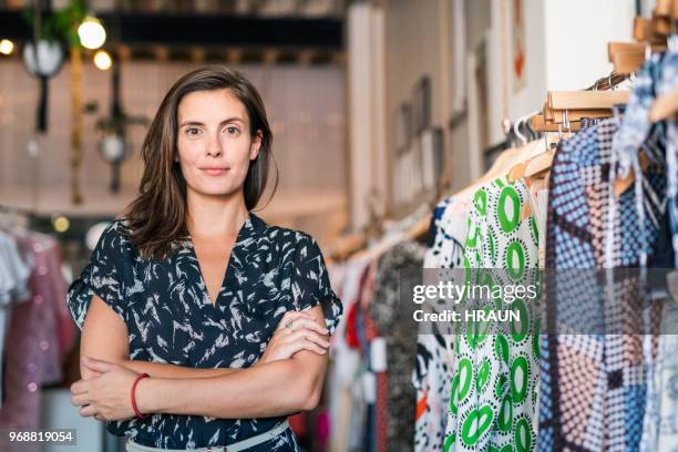 weibliche shopbetreiber mit verschränkten in boutique - clothing store stock-fotos und bilder