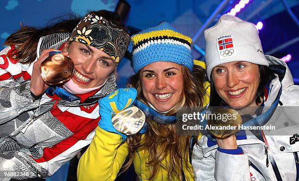 Anna Haag of Sweden celebrates winning silver, Marit Bjoergen of Norway gold , and Justyna Kowalczyk of poland Bronze during the medal ceremony for...