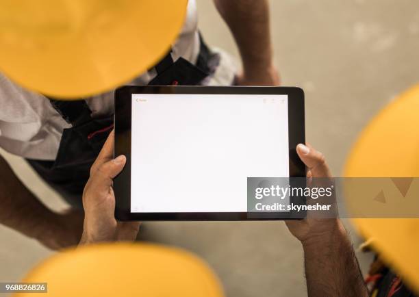 team of unrecognizable workers using digital tablet. - builders hands stock pictures, royalty-free photos & images