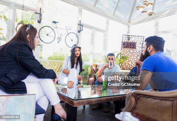 friends meeting after work at a boutique cafe in dubai - arab majlis stock pictures, royalty-free photos & images