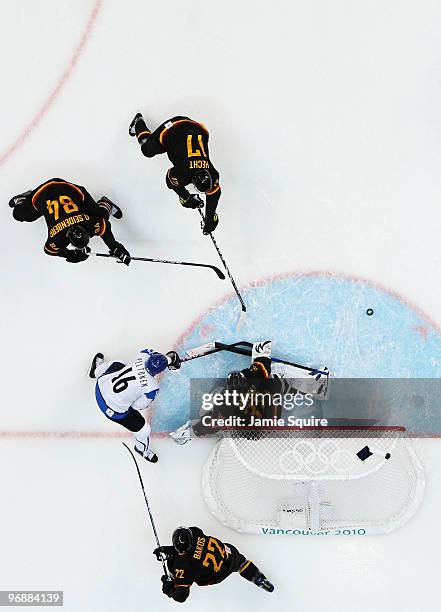 Ville Peltonen of Finland battles Dimitri Patzold of Germany and other members of the German team during the ice hockey men's preliminary game...