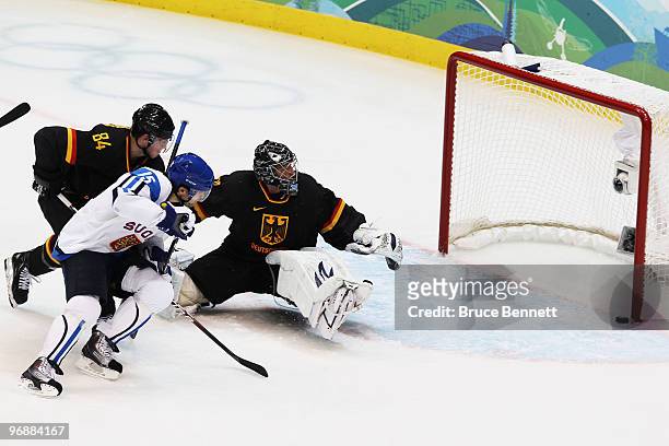 Tuomo Ruutu of Finland scores a goal against Dimitri Patzold and Dennis Seidenberg of Germany during the ice hockey men's preliminary game between...