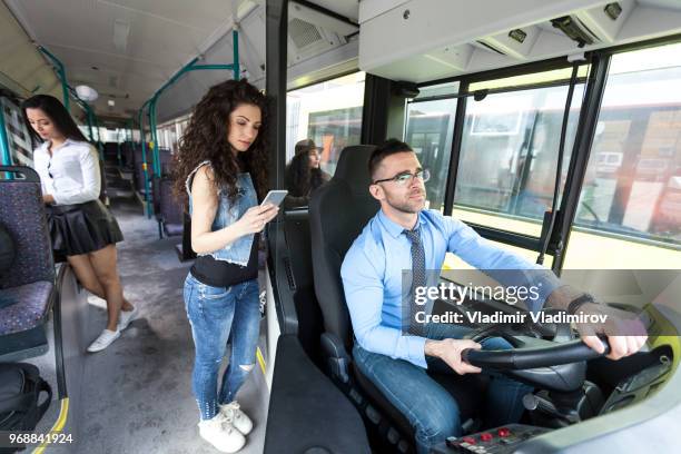 ung kvinna står bredvid föraren i en buss - förarsäte bildbanksfoton och bilder