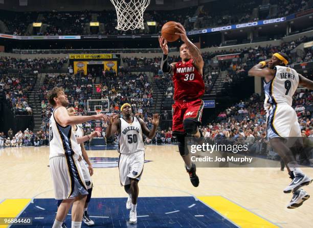 Michael Beasley of the Miami Heat shoots against Ronnie Brewer and Zach Randolph of the Memphis Grizzlies on February 19, 2010 at FedExForum in...