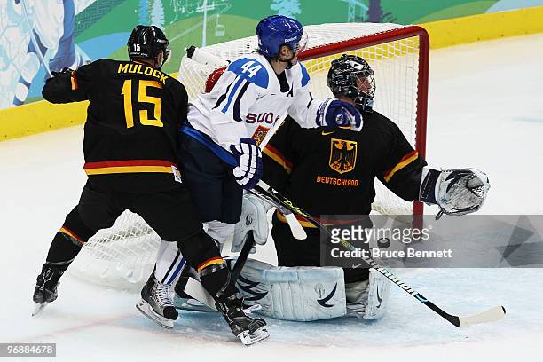 Kimmo Timonen of Finland scores a goal against Travis Mulock and goalkeeper Dimitri Patzold of Germany during the ice hockey men's preliminary game...