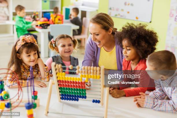 happy teacher and kids learning to count on abacus at preschool. - nursery school child stock pictures, royalty-free photos & images