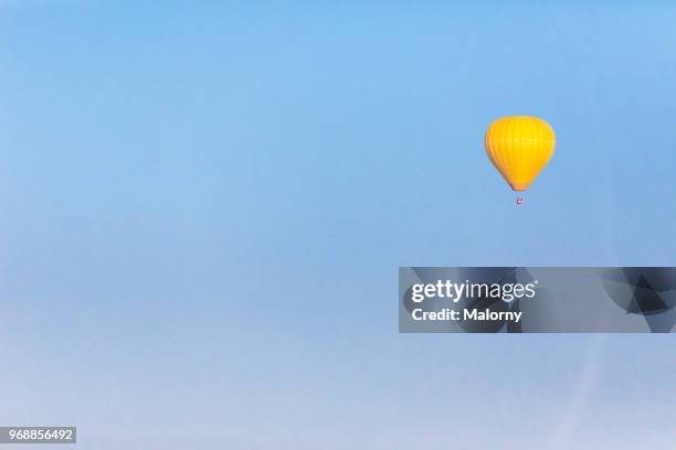 yellow hot air ballon against clear blue sky. chiemsee, chiemgau, bavaria, germany - aerial single object stock pictures, royalty-free photos & images