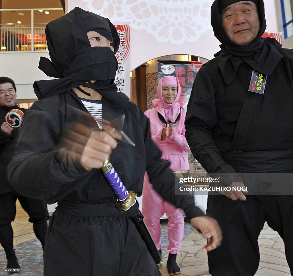 A Japanese boy dressed as a ninja throws
