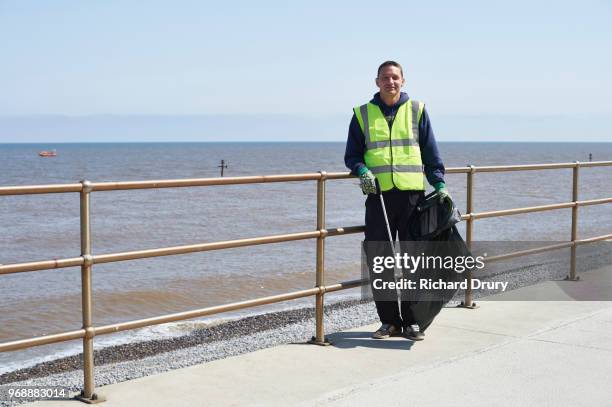 portrait of volunteer beach cleaner - volunteer beach photos et images de collection