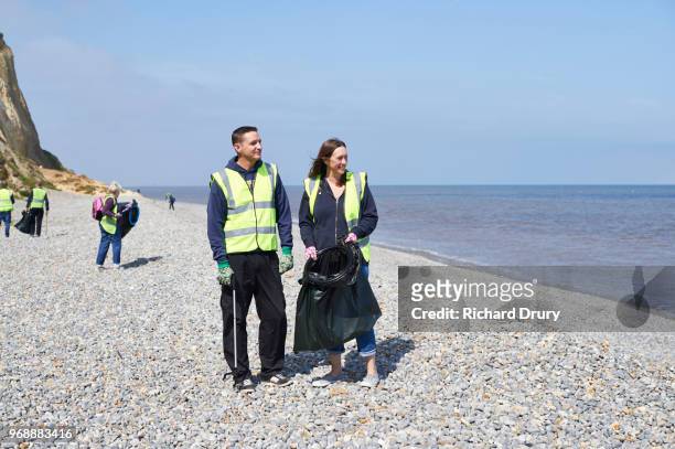 volunteer group cleaning beach - pick rubbish stock-fotos und bilder