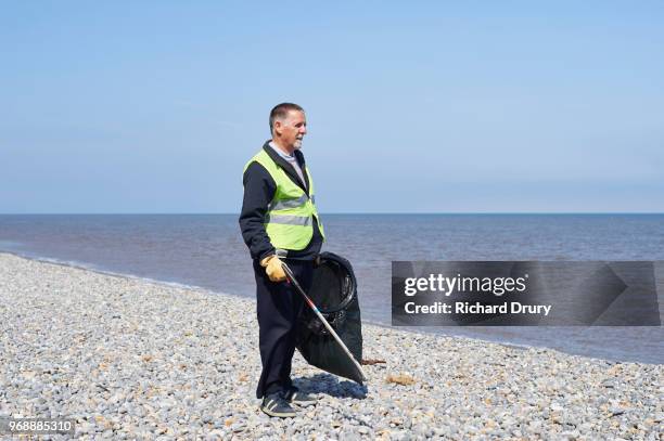 volunteer cleaning beach - pick rubbish stock-fotos und bilder