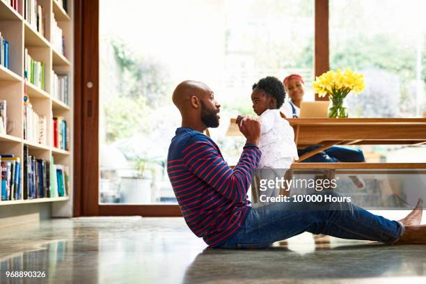 young family in livingroom - balance family stock pictures, royalty-free photos & images