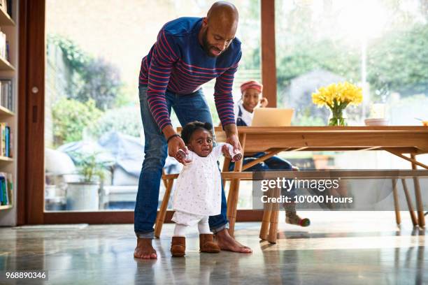 young family in livingroom - baby first steps bildbanksfoton och bilder