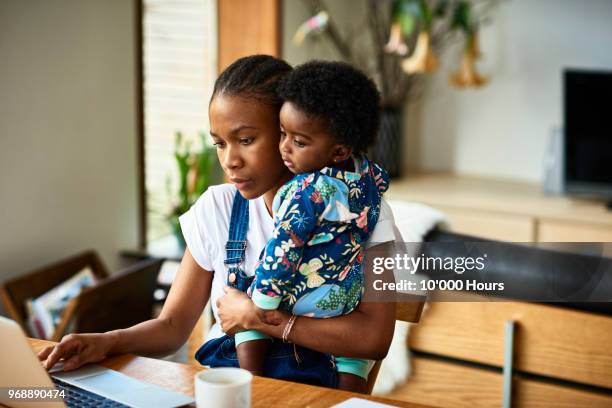 woman with baby son working - working mum stock pictures, royalty-free photos & images