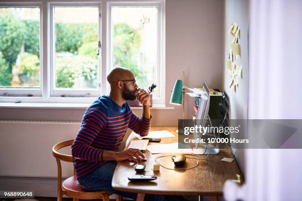 man working at home - paper england imagens e fotografias de stock