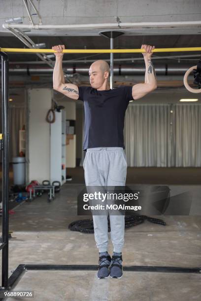 a young asian man is doing strength training - auckland train stockfoto's en -beelden