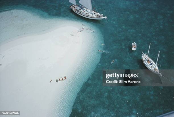High angle view of people swimming next to the ketch 'Traveler II' , Stocking Island, Bahamas, 1964.
