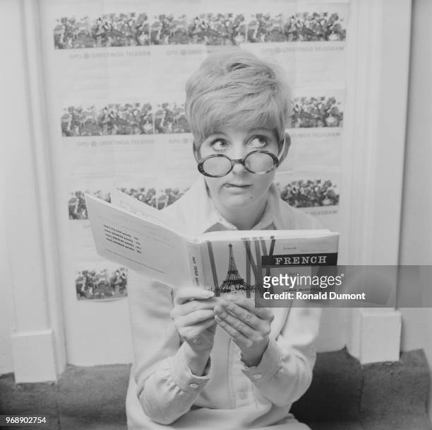 English singer, television presenter, actress and author Cilla Black reading 'Learn French Quickly' by James McConnell, UK, 6th July 1967.