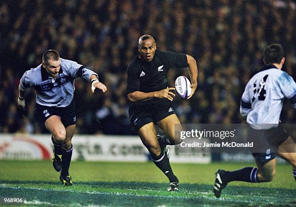 Jonah Lomu of New Zealand runs with the ball during the Rugby Union International Friendly match against Scotland played at Murrayfield, in...