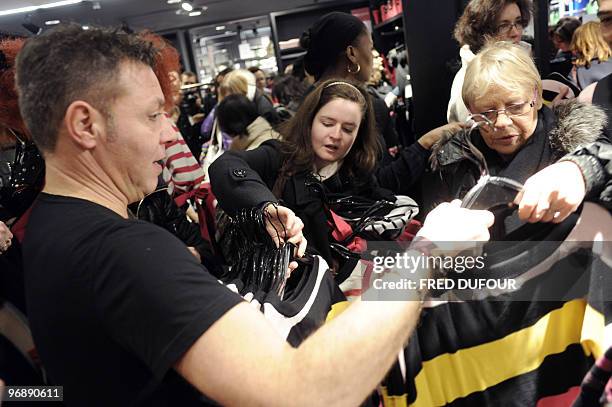 People rush to get clothes in a H&M store stocking the new collection designed by red-haired 79-year-old French designer Sonia Rykiel for H&M on...