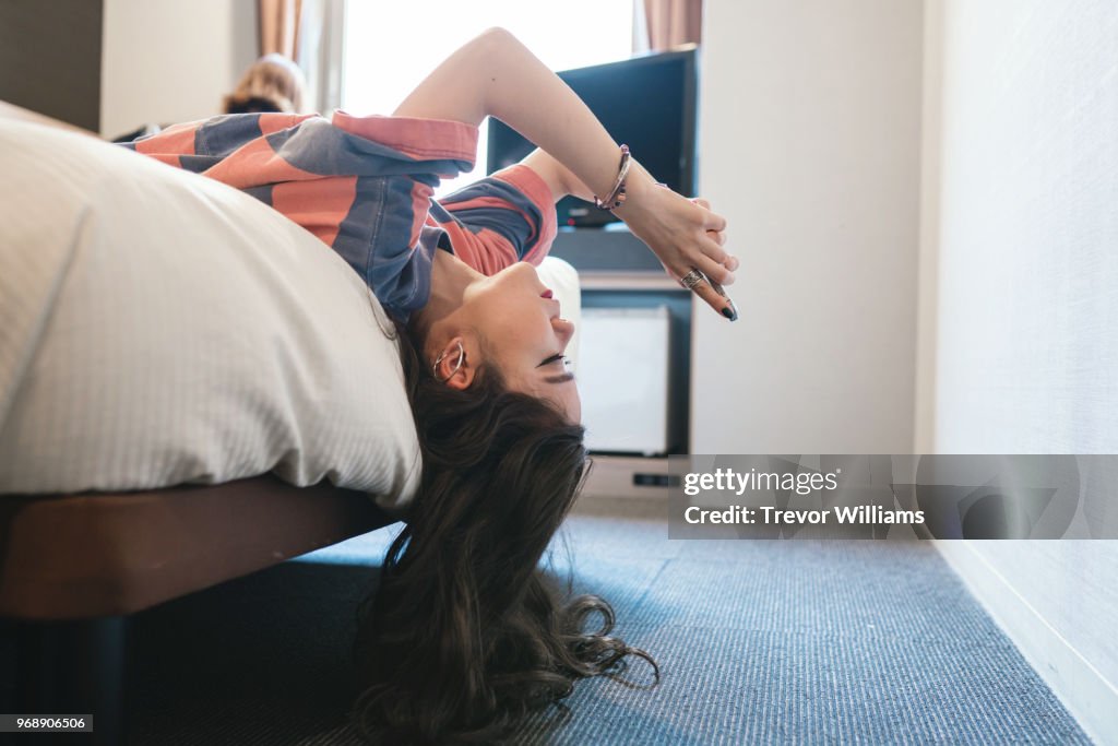 Woman looking at a smart phone on a bed