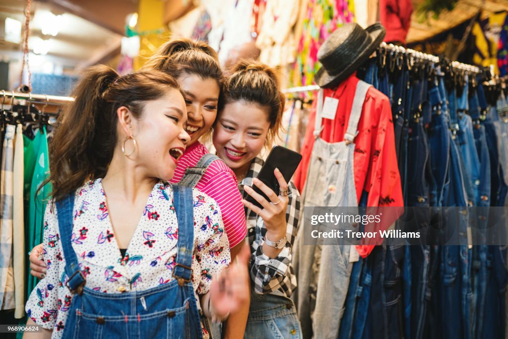 Three young woman shopping in a vintage clothing store