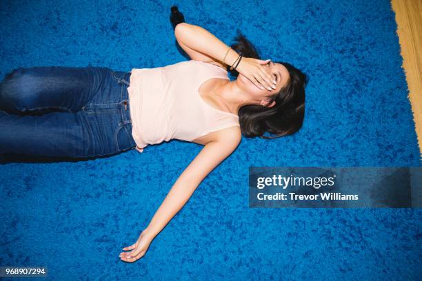 Young woman lying on the floor laughing