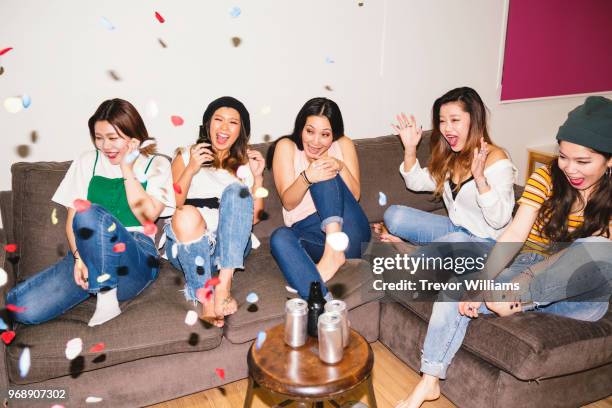 five young woman drinking beer at a social event surprised by a party cracker - hyper japan stock pictures, royalty-free photos & images