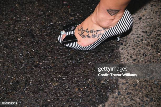 Woman's foot with tattoo in a high heel shoe