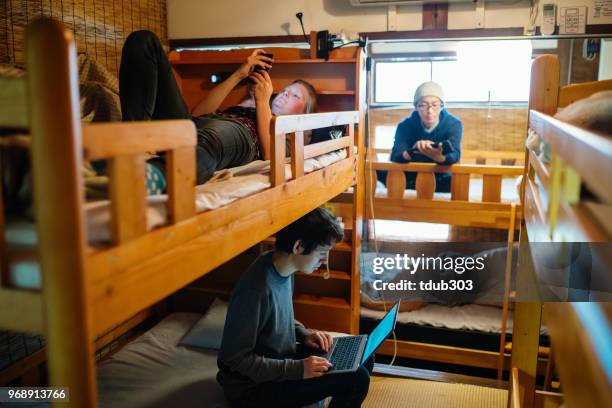 junge reisende in einem schlafsaal stil backpacker hostel mit einem laptopcomputer - bunk beds for 3 stock-fotos und bilder