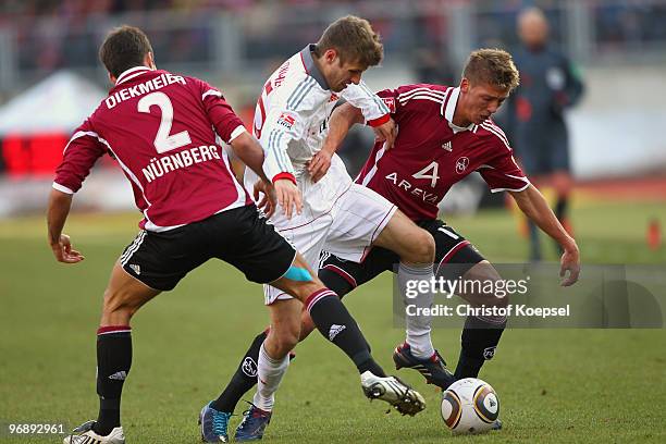 Dennis Diekmeier of Nuernberg and Javier Pinola battle for the ball with Thomas Mueller of Bayern during the Bundesliga match between 1. FC Nuernberg...