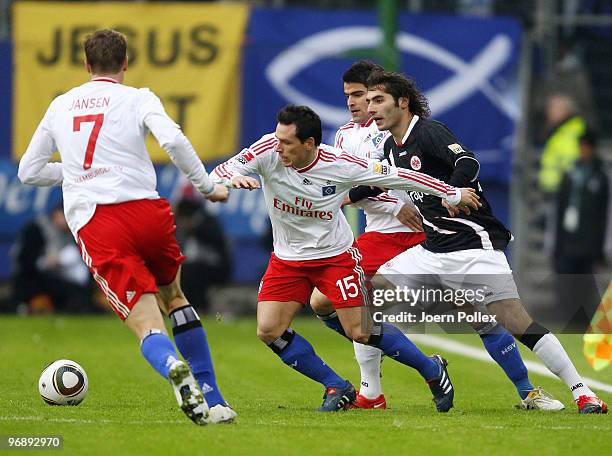 Marcell Jansen, Piotr Trochowski and Tomas Rincon of Hamburg battle for the ball with Halil Altintop of Frankfurt during the Bundesliga match between...