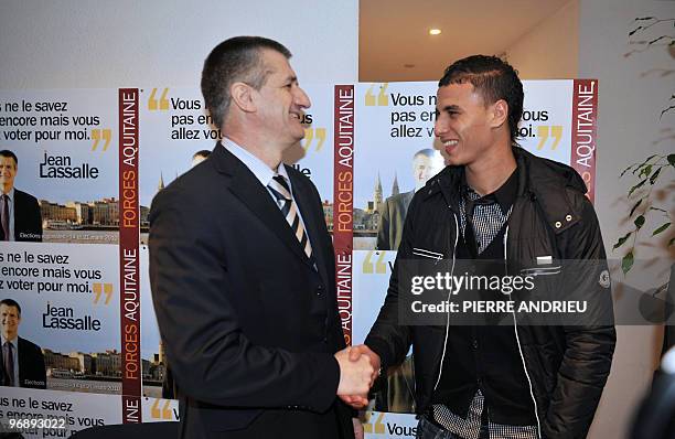 Bordeaux' French-Morrocan forward Marouane Chamakh shakes hands with French head of list for "Forces Aquitaine" Party Jean Lassalle, for the Gironde...