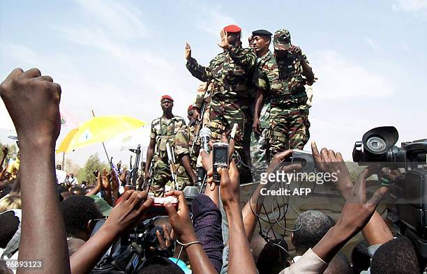Peopel cheer and take photos of membesr of the military junta during a rally in Niger's capital Niamey on February 20, 2010 in support of their new...