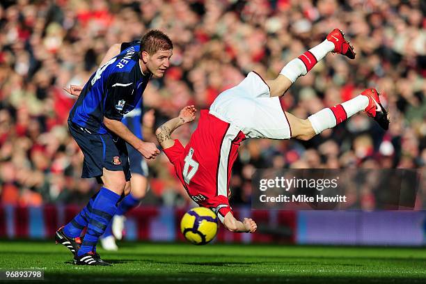 Cesc Fabregas of Arsenal is upended by Michael Turner of Sunderland during the Barclays Premiere League match between Arsenal and Sunderland at...