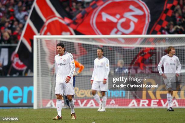 Mario Gomez, Martin Demichelis and Holger Badstuber of Bayern look dejected after receiving the first goal of Nuernberg during the Bundesliga match...